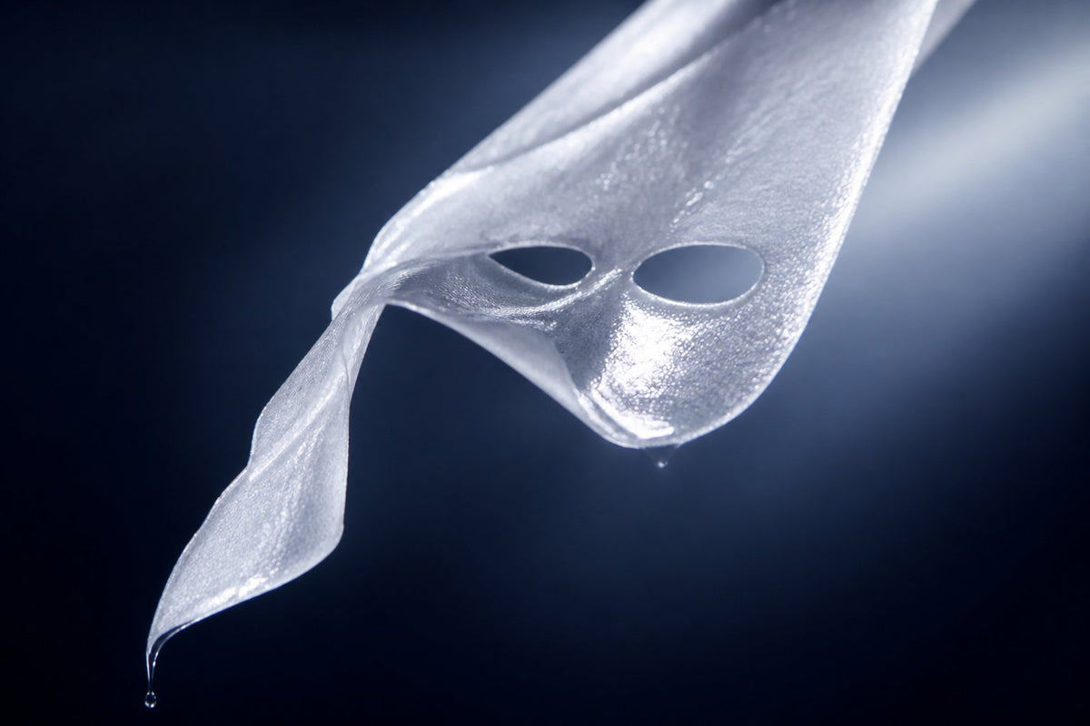 macro of a mask mid-unfold, essence catching the light